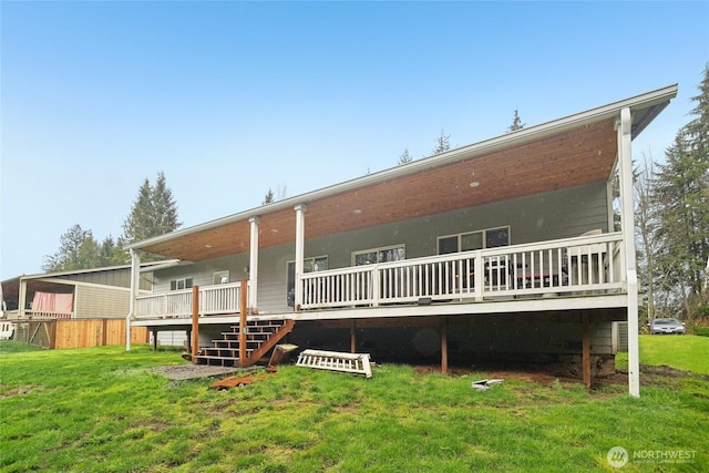 back of house featuring a wooden deck and a lawn
