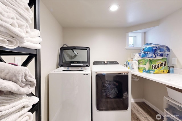 laundry area featuring baseboards, washer and clothes dryer, laundry area, and wood finished floors