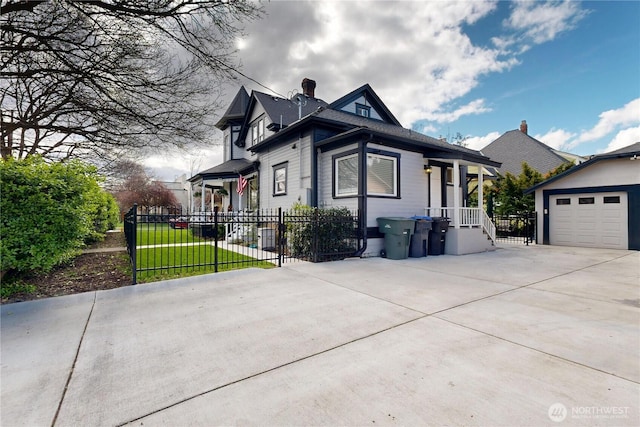 view of front of property with concrete driveway, an outdoor structure, fence, and a garage