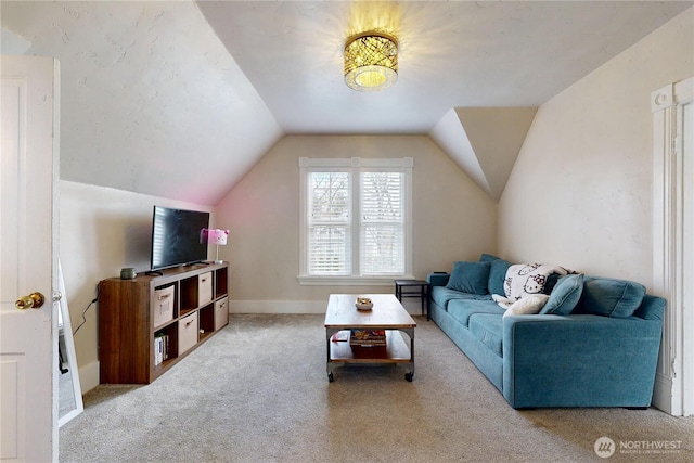 carpeted living room with baseboards and lofted ceiling