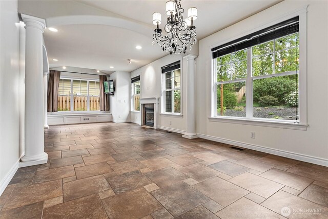 unfurnished living room featuring baseboards, decorative columns, a fireplace, and recessed lighting