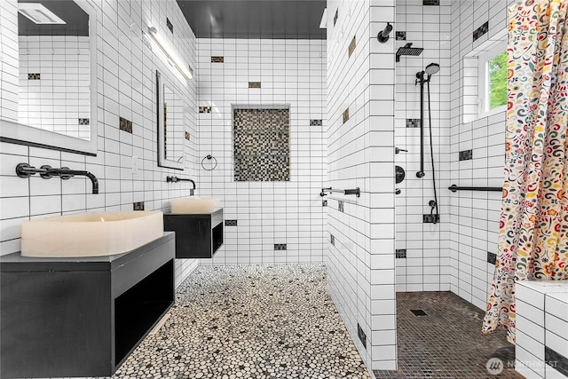 bathroom featuring tiled shower, tile walls, and vanity