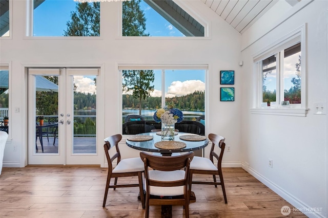 dining space with lofted ceiling, wood finished floors, wooden ceiling, french doors, and baseboards