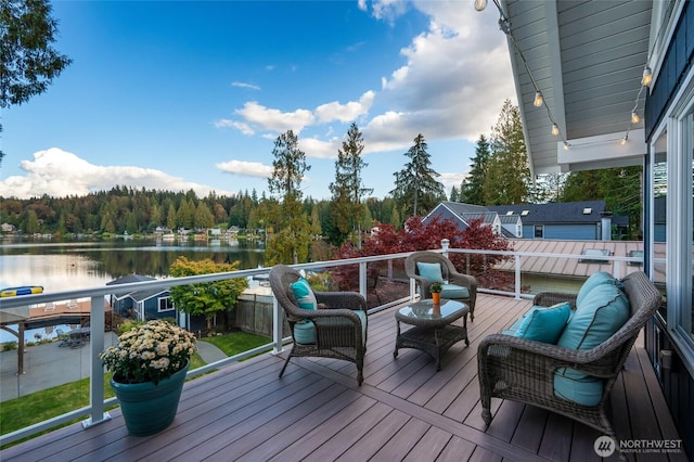 deck with a forest view, a water view, and an outdoor living space