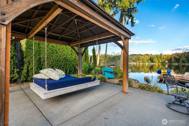 view of patio with a view of trees, a gazebo, and a water view