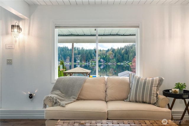 living area with wood finished floors, baseboards, a water view, and wooden ceiling