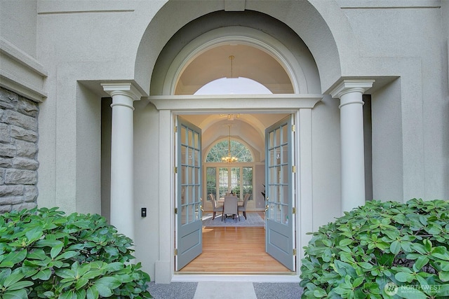 doorway to property with french doors, stone siding, and stucco siding