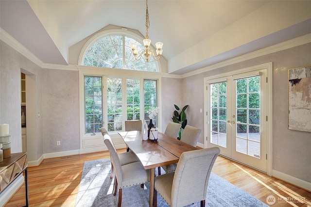 dining space featuring plenty of natural light, a notable chandelier, light wood finished floors, and french doors