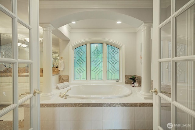 full bath with crown molding, a bath, and ornate columns