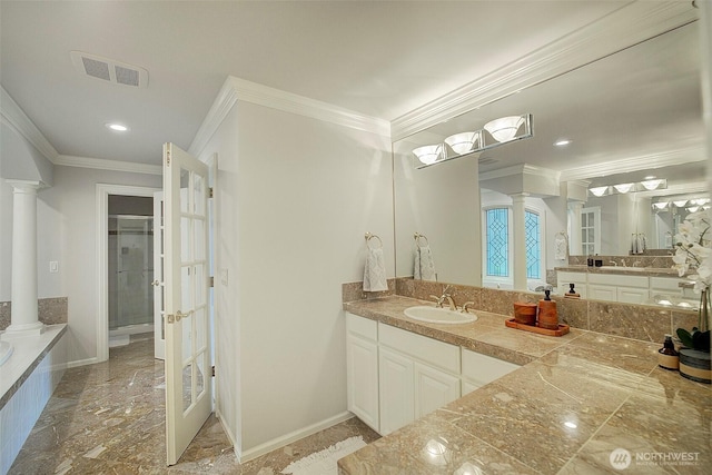 bathroom with decorative columns, a garden tub, visible vents, and ornamental molding