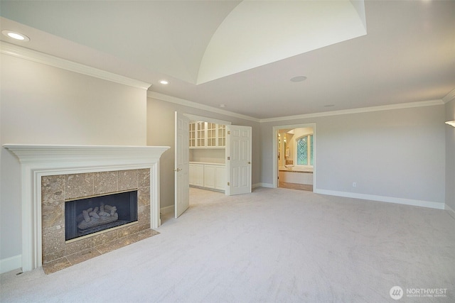 unfurnished living room featuring a tile fireplace, light colored carpet, baseboards, and ornamental molding