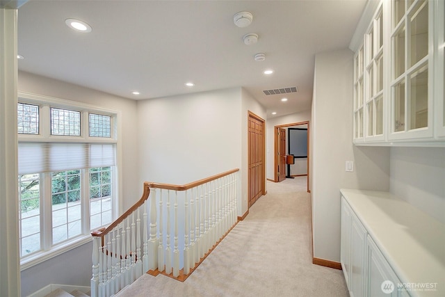 corridor with light carpet, baseboards, visible vents, and recessed lighting