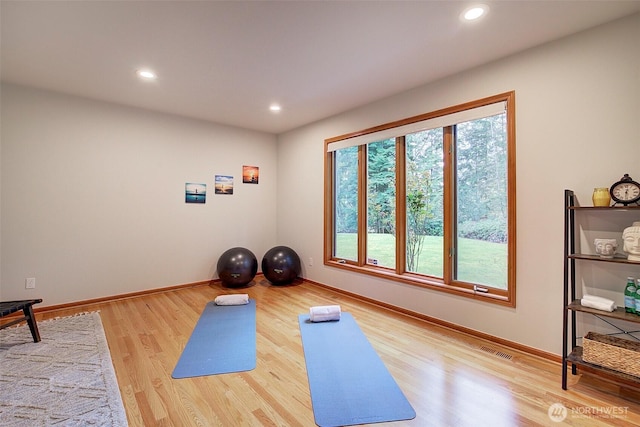 exercise area featuring wood finished floors, baseboards, visible vents, and recessed lighting