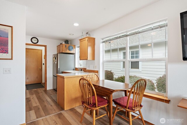 1021 Sinclair Way Unit 38, Burlington, WA 98233 - kitchen with light countertops, a peninsula, recessed lighting, light wood-type flooring, and freestanding refrigerator