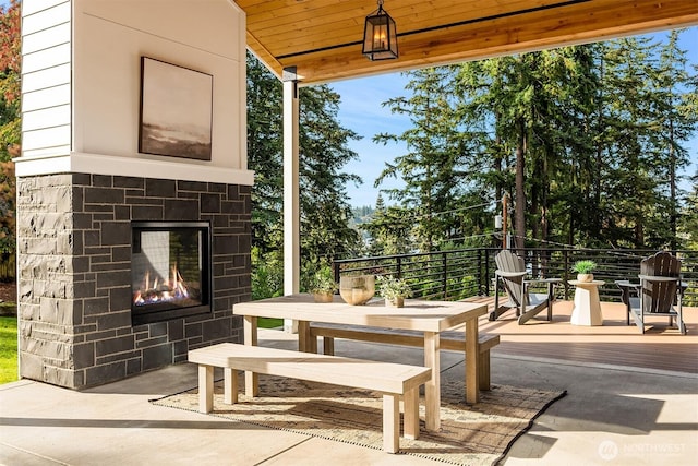 view of patio with an outdoor stone fireplace and outdoor dining space