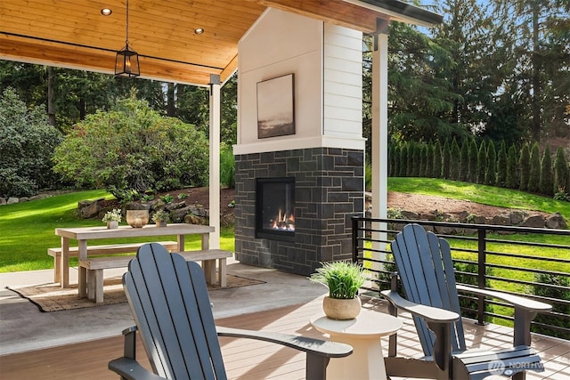 view of patio / terrace with outdoor dining area and an outdoor stone fireplace