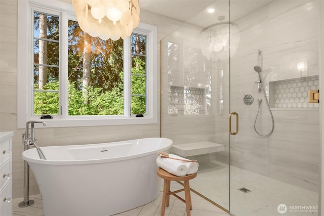 bathroom featuring a freestanding tub, tile walls, and a stall shower