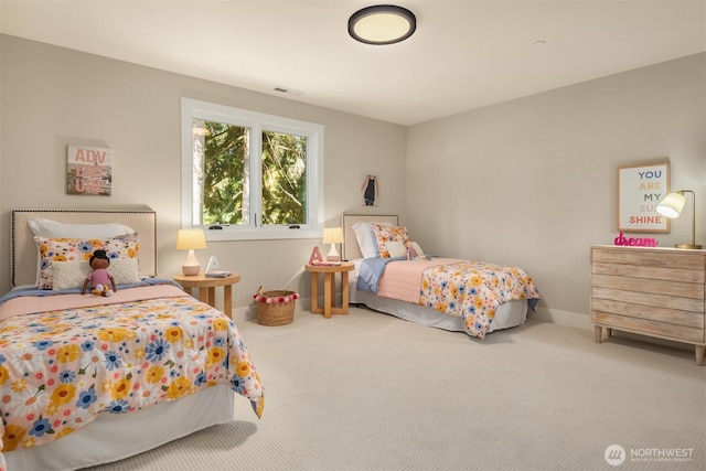carpeted bedroom featuring baseboards and visible vents