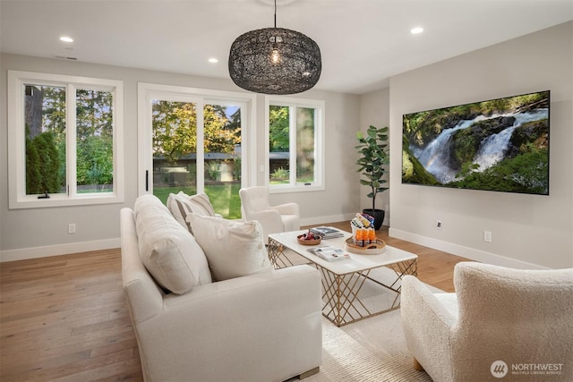 living room featuring visible vents, baseboards, light wood-style floors, and recessed lighting