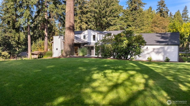 view of front of property featuring a standing seam roof and a front lawn