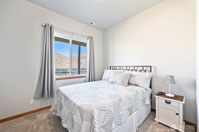 bedroom featuring visible vents, baseboards, and carpet