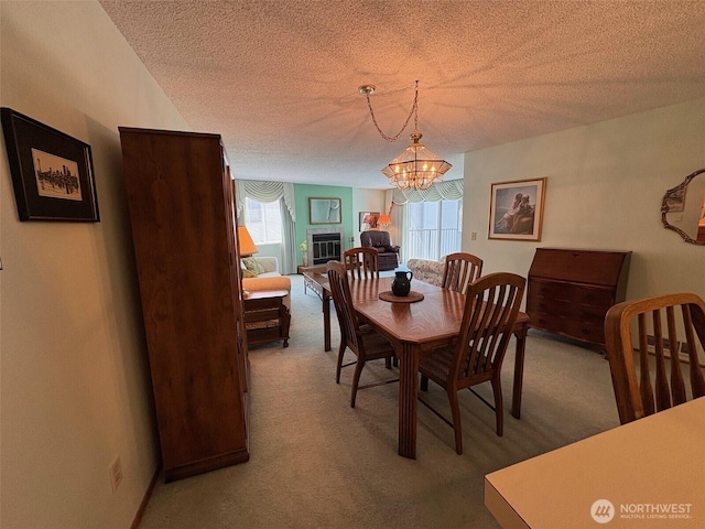 carpeted dining room with a textured ceiling and a chandelier