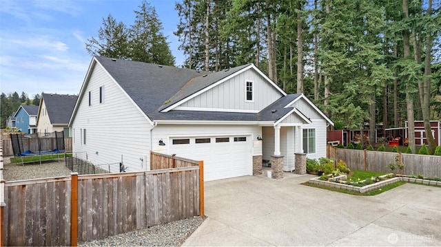 6620 165th Street Ct E, Puyallup, WA 98375 - view of front of house featuring board and batten siding, concrete driveway, a trampoline, a shingled roof, and a garage