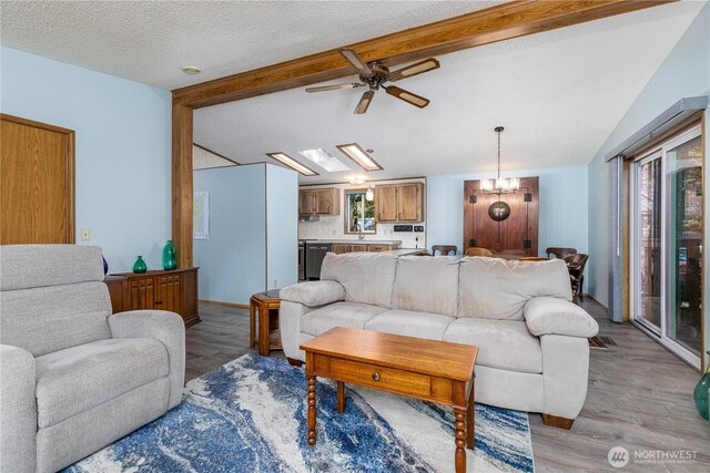 161 N Dow Mountain Rd, Hoodsport, WA 98548 - living area featuring ceiling fan with notable chandelier, vaulted ceiling with beams, light wood-style floors, and a textured ceiling