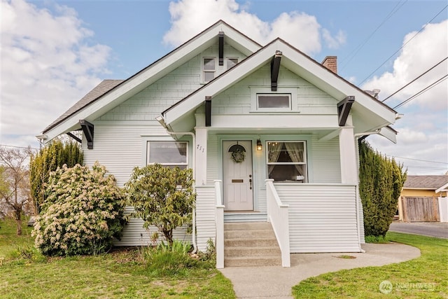 bungalow-style home with a chimney and a porch