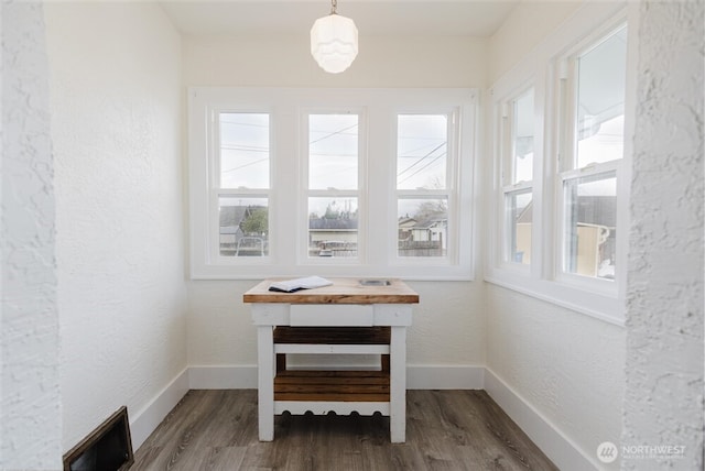details featuring wood finished floors, a textured wall, baseboards, and visible vents