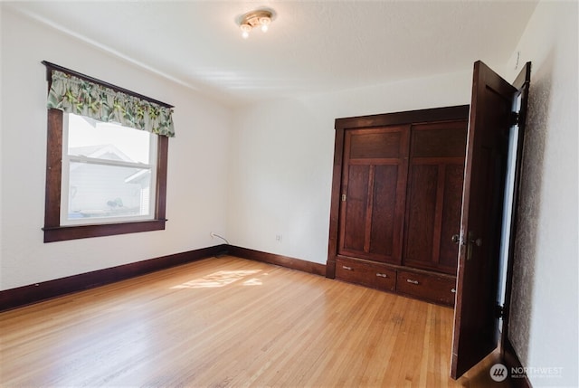 unfurnished bedroom with baseboards and light wood-type flooring