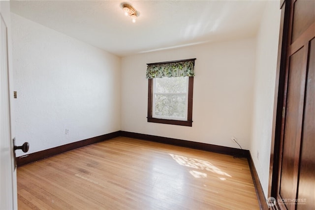 empty room with baseboards and light wood-style floors
