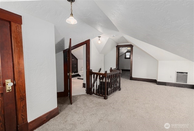 bonus room featuring a textured ceiling, carpet, baseboards, heating unit, and vaulted ceiling