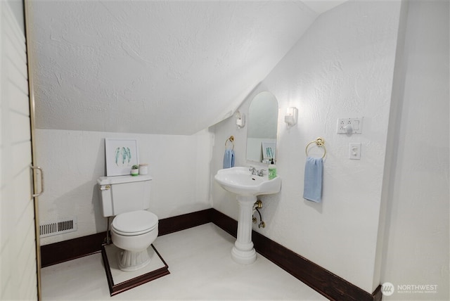 bathroom featuring lofted ceiling, toilet, baseboards, a textured ceiling, and visible vents