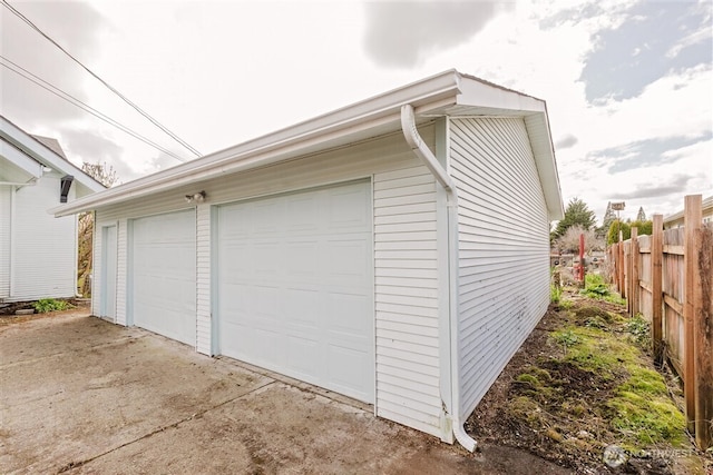 detached garage featuring fence
