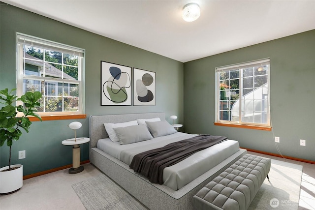 bedroom with multiple windows, carpet floors, and baseboards