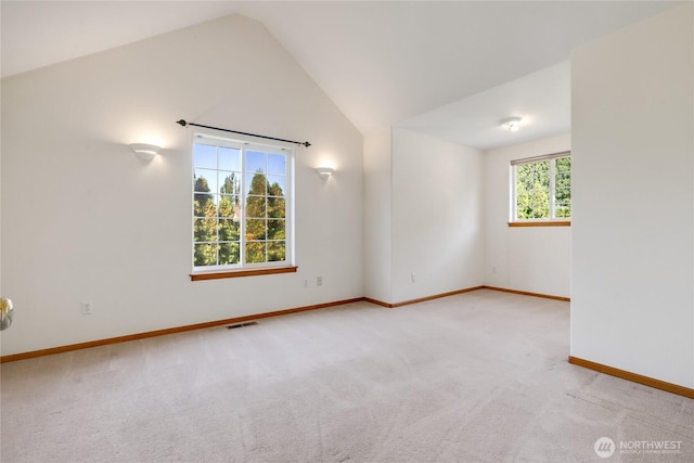 unfurnished room with carpet flooring, baseboards, vaulted ceiling, and visible vents