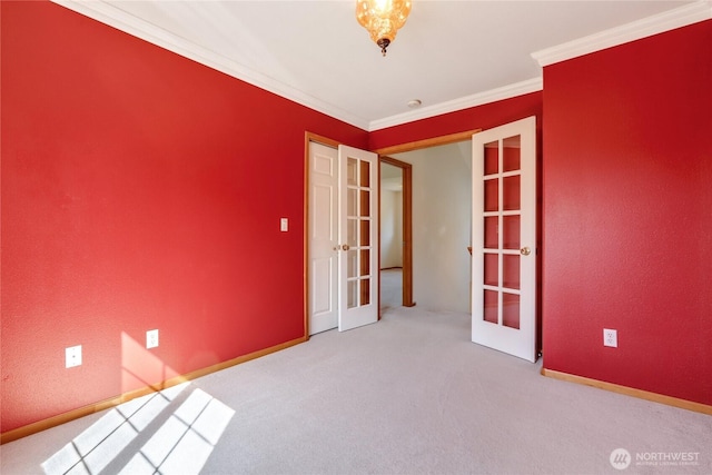 spare room featuring baseboards, crown molding, carpet floors, and french doors