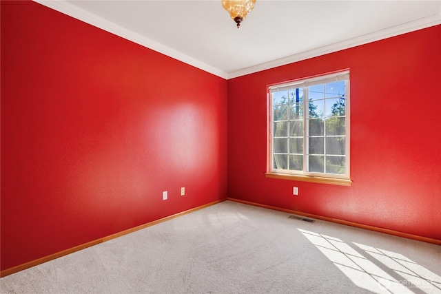 empty room featuring carpet flooring, crown molding, baseboards, and visible vents