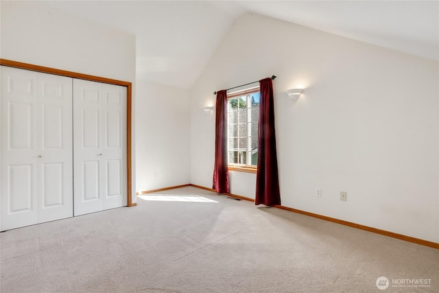 unfurnished bedroom with baseboards, vaulted ceiling, a closet, and carpet