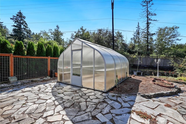 view of greenhouse with a fenced backyard