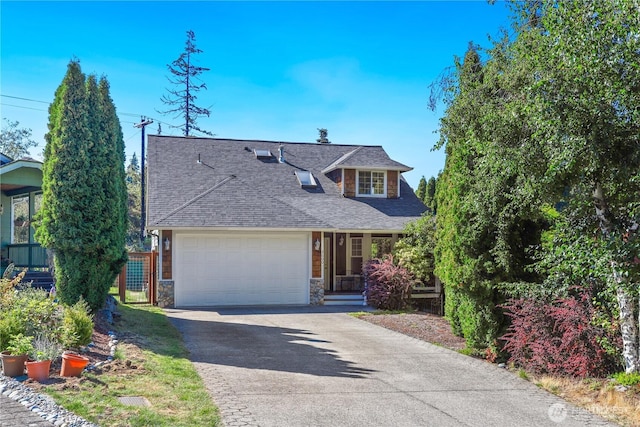view of front facade featuring stone siding, a shingled roof, an attached garage, and driveway