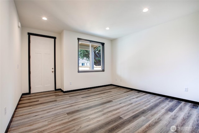 empty room with recessed lighting, baseboards, and light wood finished floors