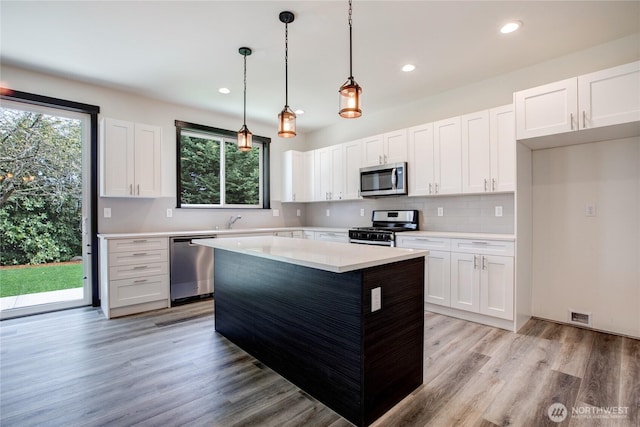 kitchen featuring light countertops, white cabinets, light wood-style floors, and stainless steel appliances