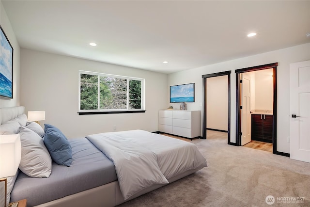 bedroom with recessed lighting, light carpet, and ensuite bath