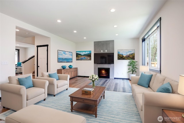 living area with a fireplace, recessed lighting, and light wood-style floors