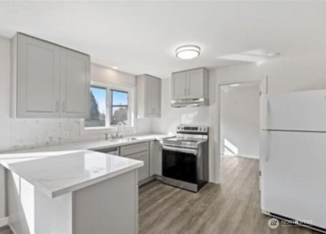 10601 55th Ave S, Seattle, WA 98178 - kitchen featuring a sink, freestanding refrigerator, stainless steel electric range, a peninsula, and gray cabinetry