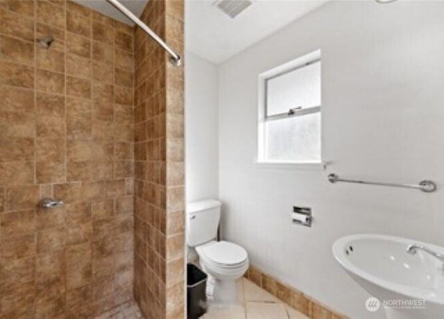 10601 55th Ave S, Seattle, WA 98178 - full bathroom with tile patterned floors, a tile shower, toilet, and a sink