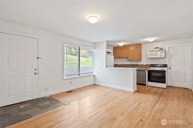 10601 55th Ave S, Seattle, WA 98178 - kitchen featuring range with electric cooktop, light wood-type flooring, stainless steel dishwasher, and white microwave