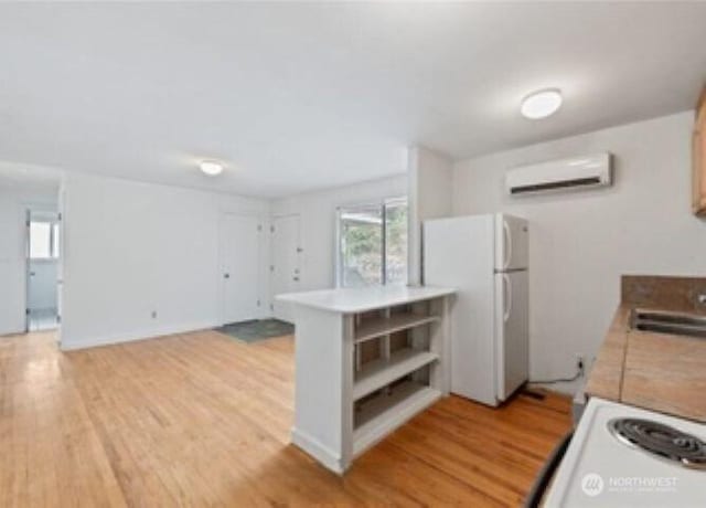 10601 55th Ave S, Seattle, WA 98178 - kitchen with a sink, open shelves, white appliances, light wood-style floors, and an AC wall unit